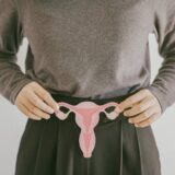 Woman hands holding uterus, female reproductive system ,PCOS, gynecologic and cervix cancer concept